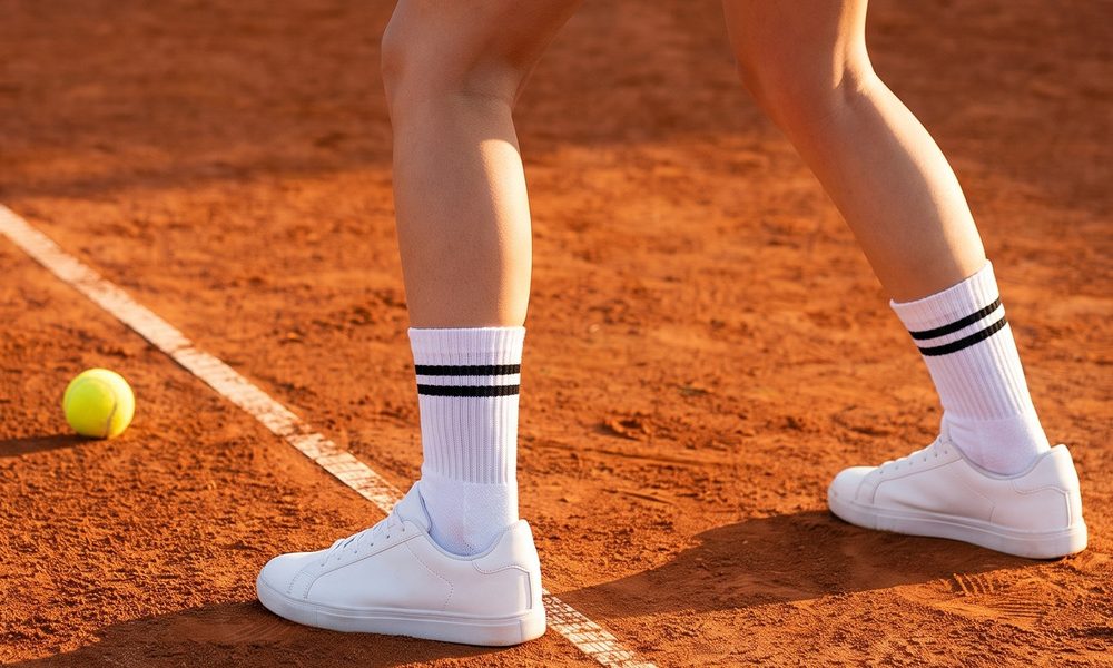 A+ Bild: Tennissocken auf dem Sandplatz